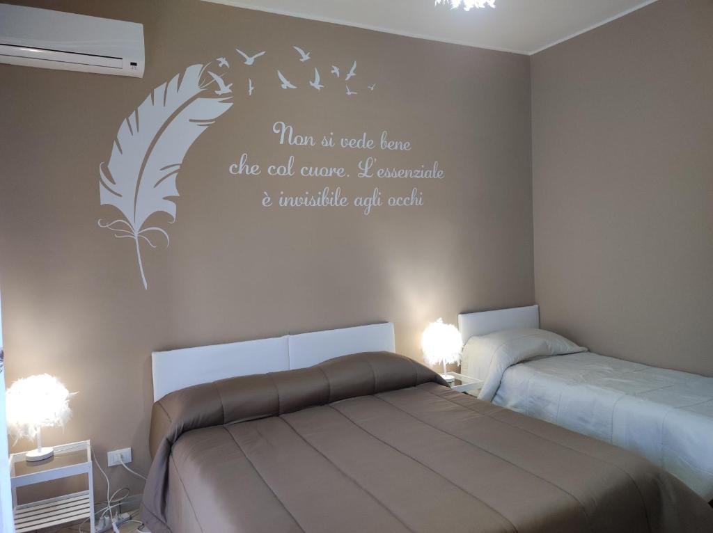 a bedroom with two beds and a quote on the wall at Bed and Breakfast Oasi in Reggio Calabria