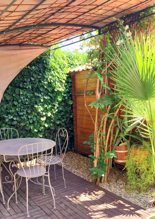 un patio avec une table, des chaises et des plantes dans l'établissement Clos Réginel Remparts Sud, à Avignon