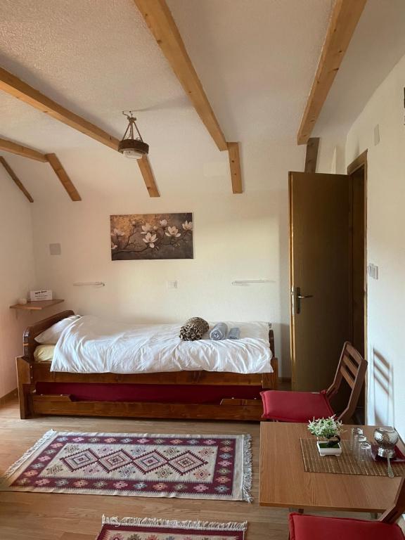 弗拉西克Apartmani BIR-Bee Vlašić的房间里有一张床和一张桌子的卧室