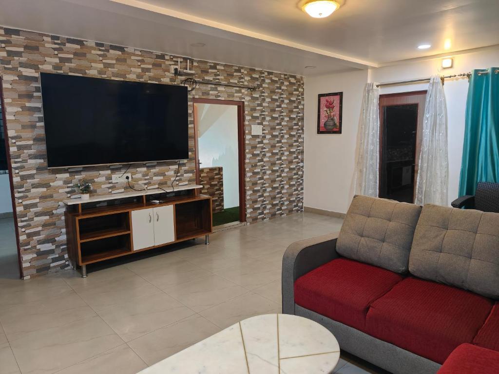 a living room with a couch and a tv on a brick wall at Hotel serenity villa in Guwahati
