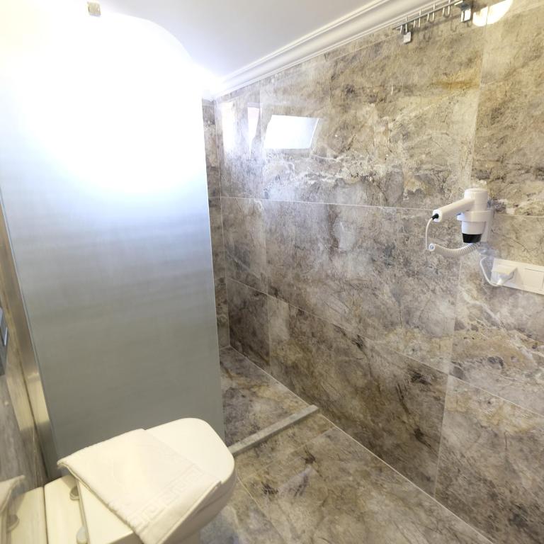 a bathroom with a shower stall and a toilet at Yaz Villa in Fethiye