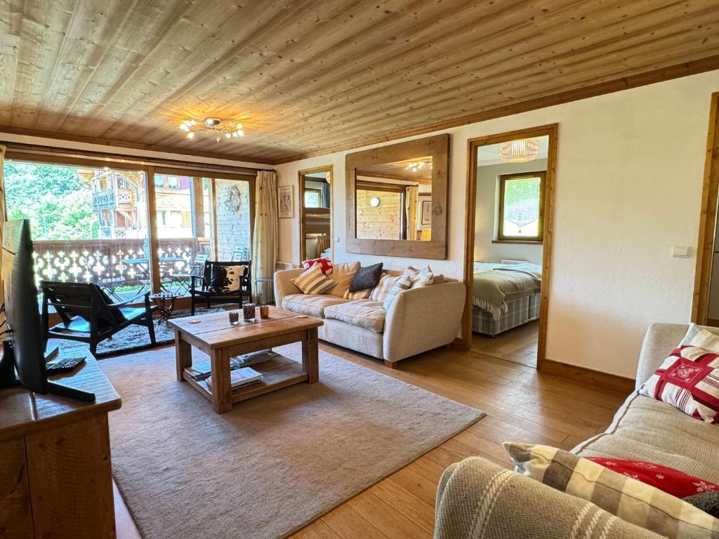 un salon avec un canapé et une table dans l'établissement Appartement 3 chambres avec balcon, proche des pistes, parking, WiFi, TV avec Netflix et Amazon. - FR-1-623-79, aux Gets