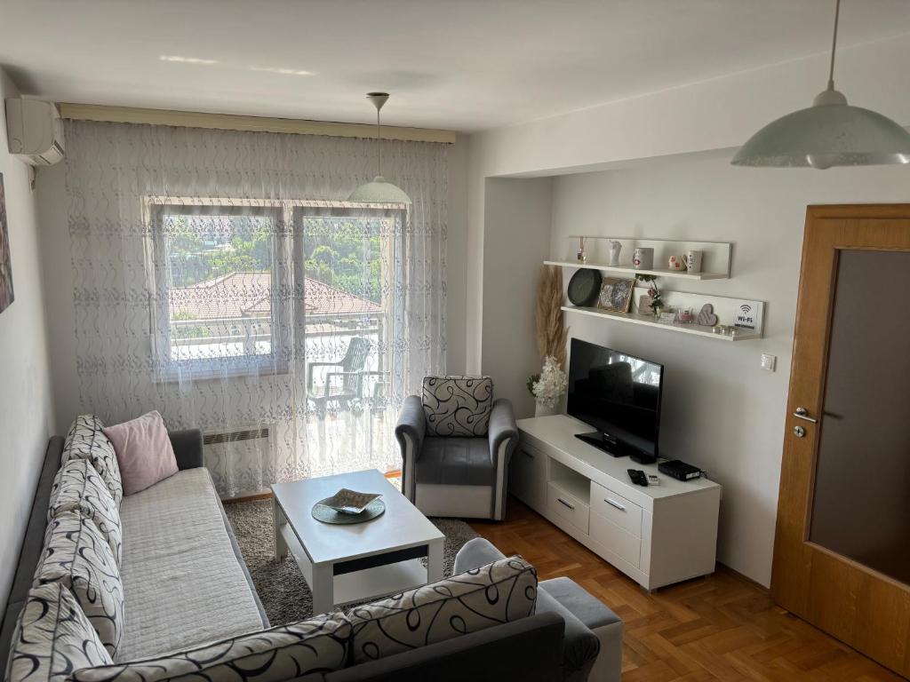 a living room with a couch and a tv at Cozy corner Mostar in Mostar