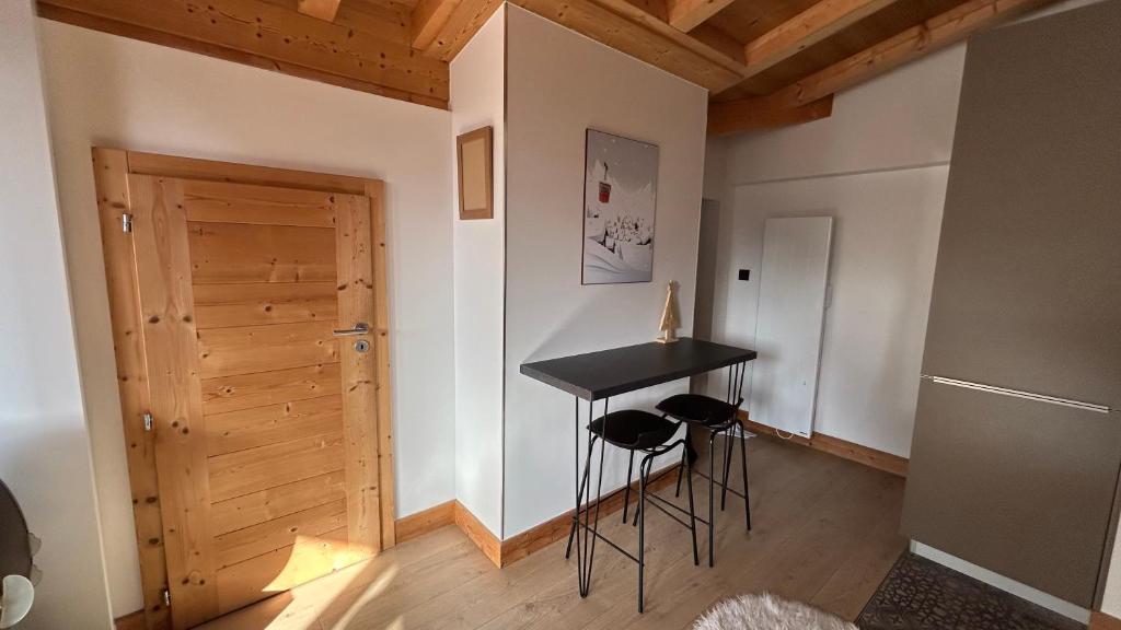 a room with a table and stools and a door at Roof top Moutain view direct access Morzine Avoriaz in Montriond