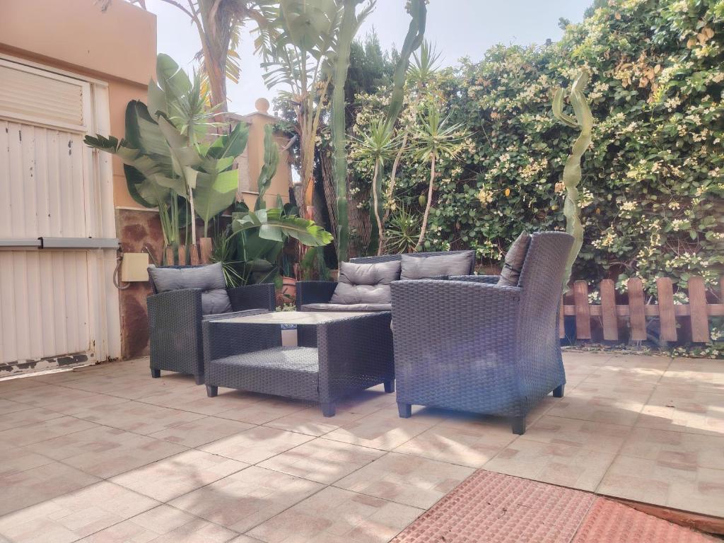un patio con 3 sillas y una mesa en APARTAMENTO JAZMINERO, en Aguadulce