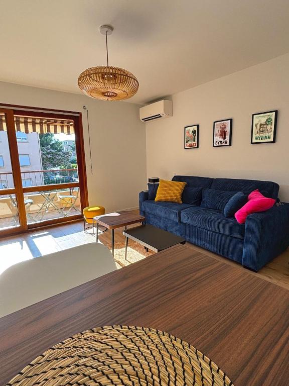 un salon avec un canapé bleu et une table dans l'établissement Grand Studio Cozy, 650m de la plage et 200m du tennis club, à Six-Fours-les-Plages