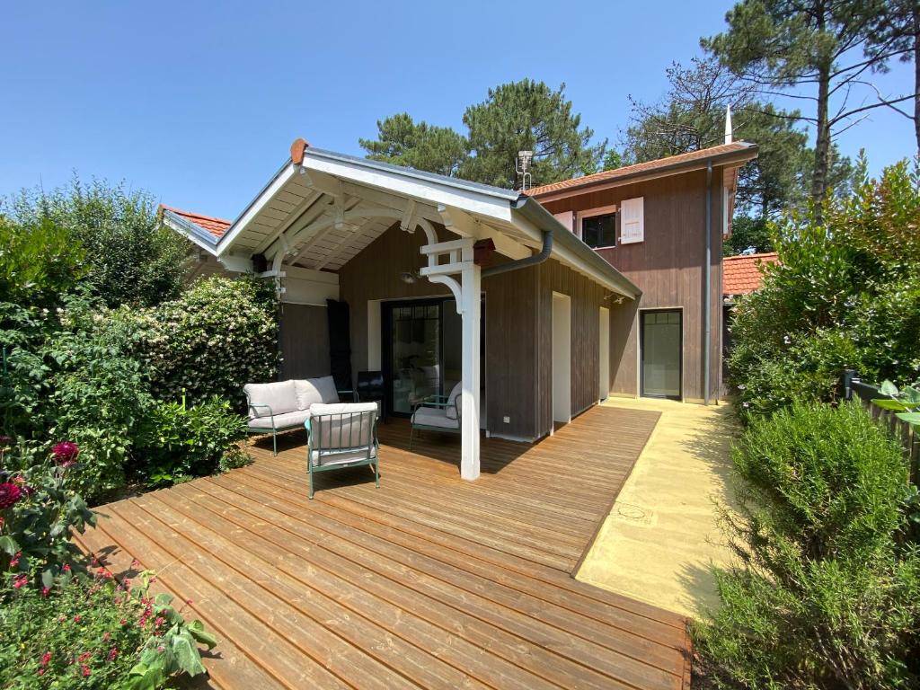 une terrasse en bois avec un toit sur une maison dans l'établissement Maison vacance eco quartier, à La Teste-de-Buch