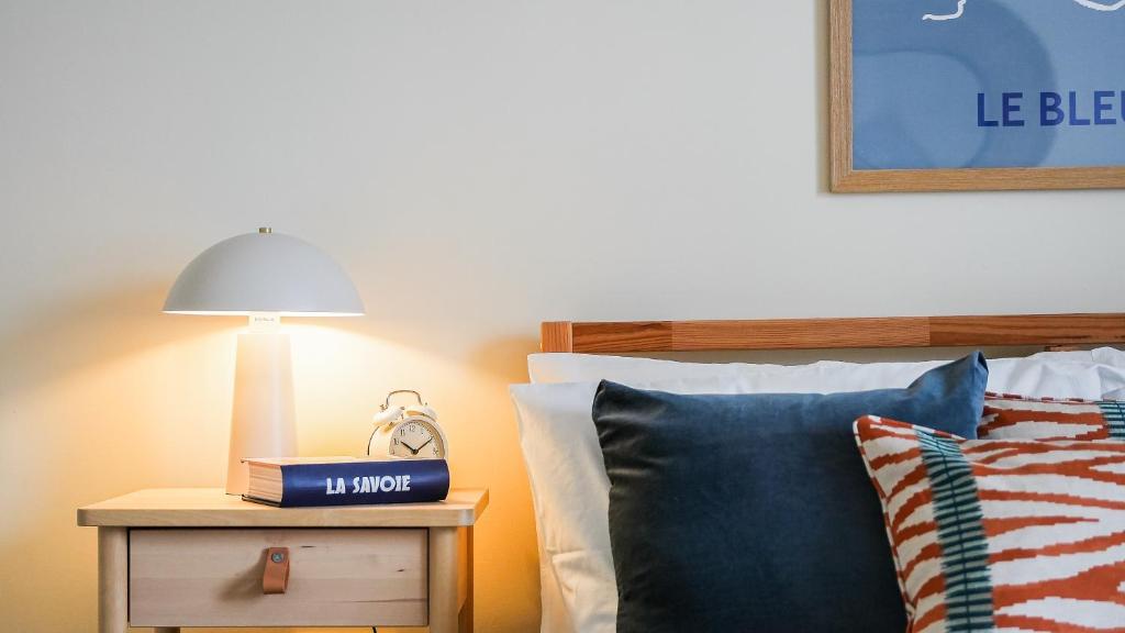 a bed with a lamp on a table next to a bed at Crookes Gem with Garden & Alpacas Nearby in Walkley