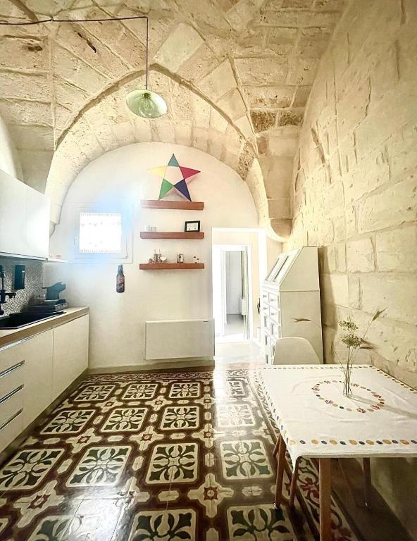 a kitchen with a table in a room with a stone wall at Il Melograno in Cavallino di Lecce