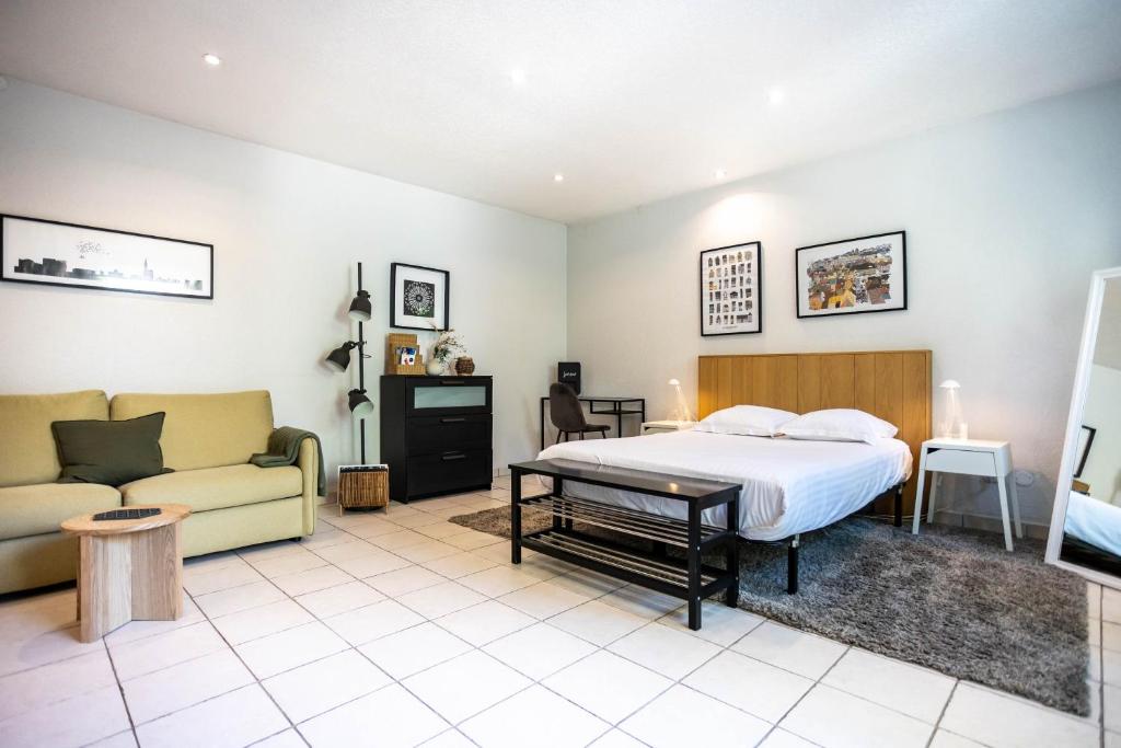 ein Schlafzimmer mit einem Bett und einer Couch in der Unterkunft les Jardiniers in Straßburg