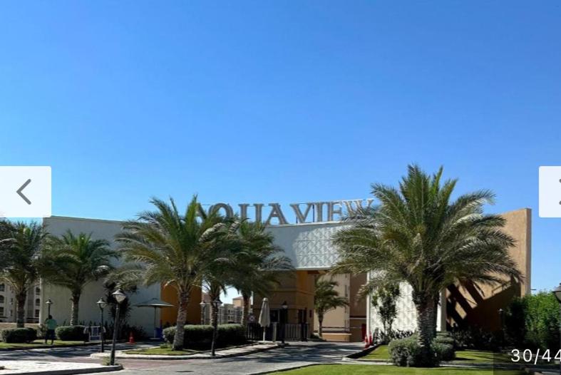 un hotel con palmeras frente a un edificio en Aqua view resort studio, en El Qasaba esh Sharqīya