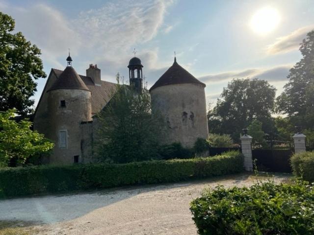 un vecchio edificio con una torre sopra di Logement Château de Villeneuve 