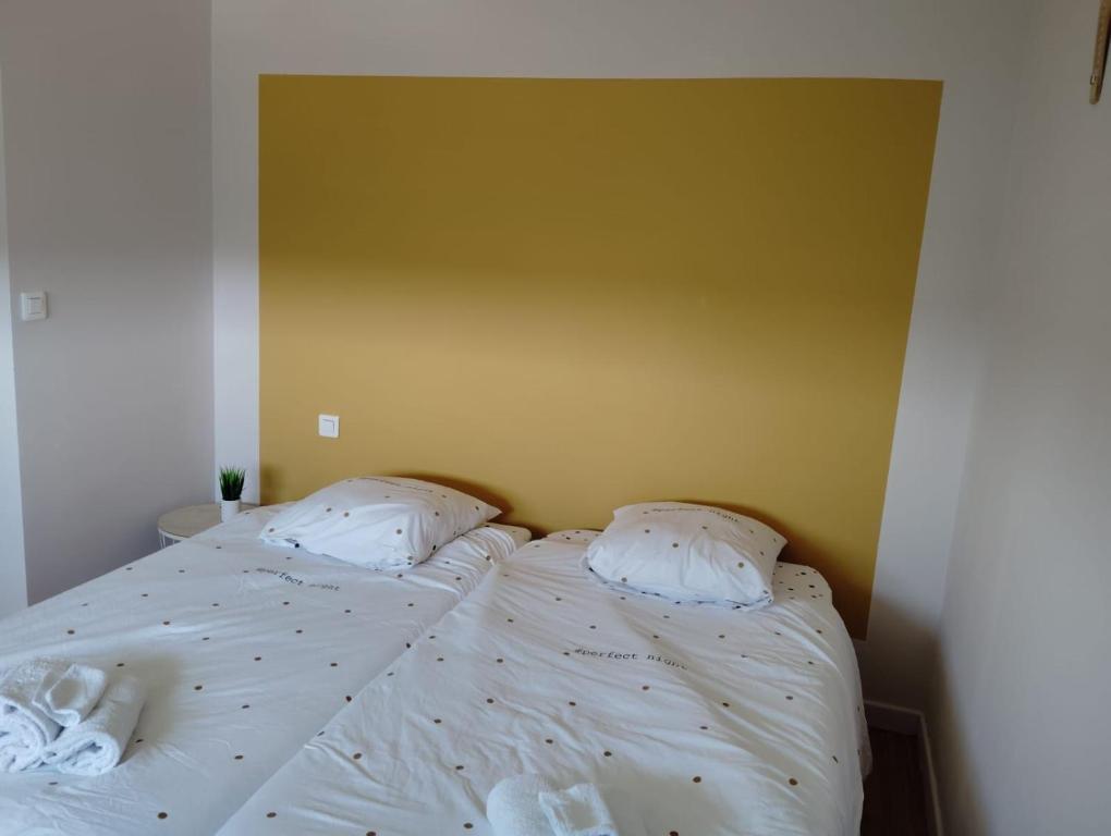 a bed with white sheets and pillows in a bedroom at Appartement climatisé avec parking à Albi in Albi