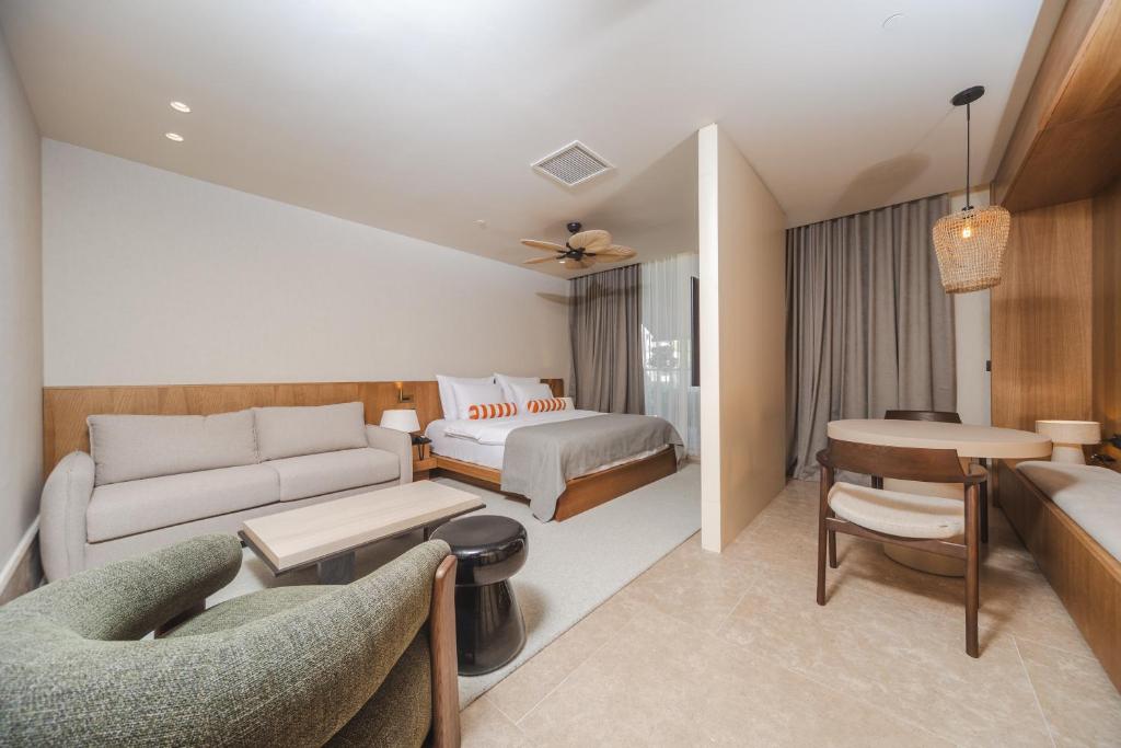 uma sala de estar com um sofá e uma cama em Infinity Hotel & More em Budva