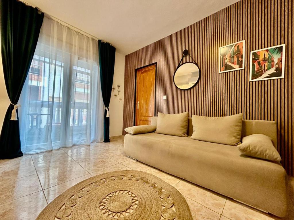 Una sala de estar con un sofá y un espejo. en Hola Torrevieja, en Torrevieja
