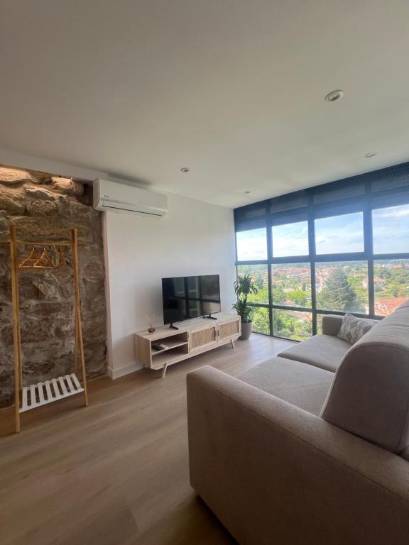 トゥイにあるApartamentos-loft A Murallaのソファと薄型テレビのあるリビングルーム