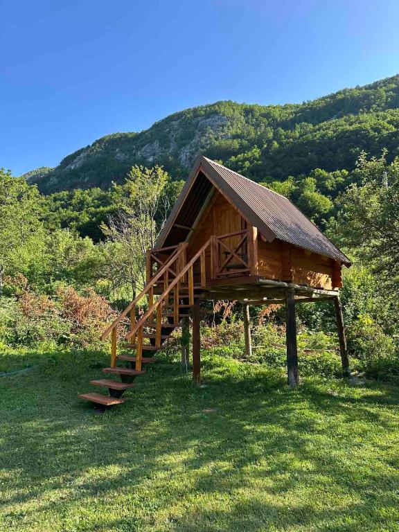 a small building with a staircase in the grass at Bungalov Veruša in Podgorica