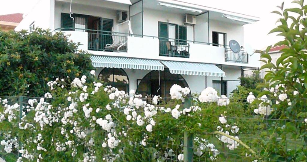 un edificio con flores blancas delante de él en Trogirsunset Apartments, en Trogir