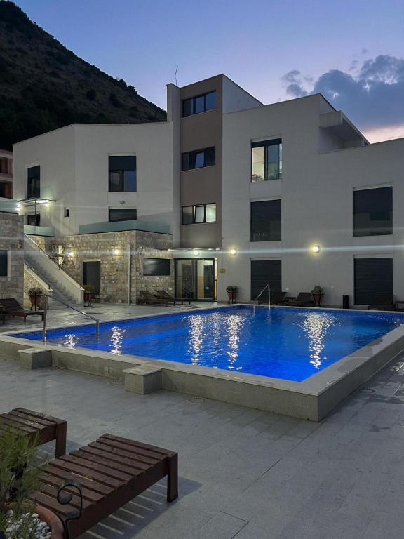 a house with a large swimming pool in front of a building at I&I Apartment in Igalo