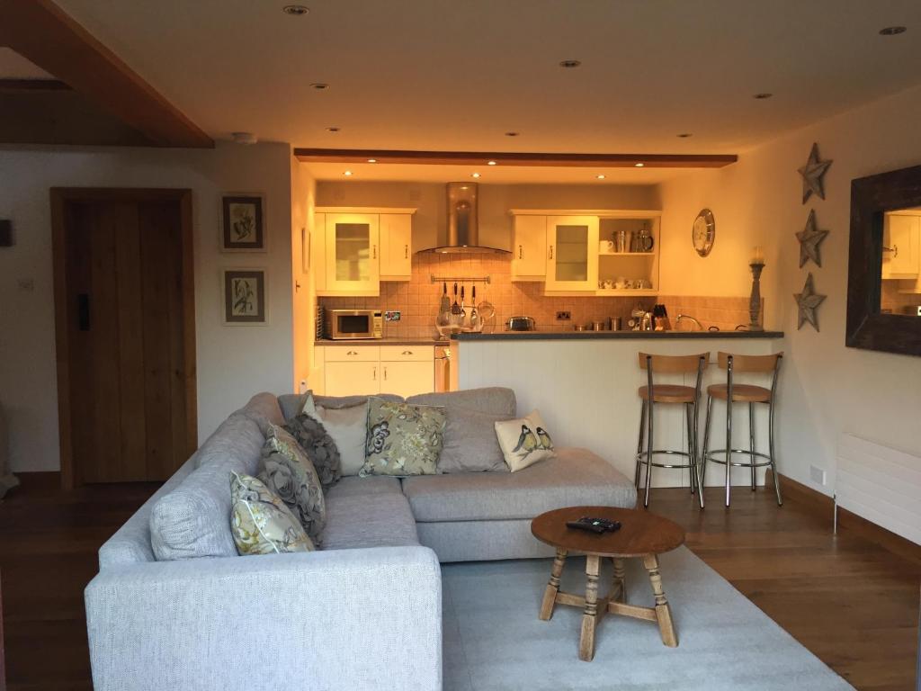 a living room with a couch and a kitchen at The Apple Shed in Farmborough