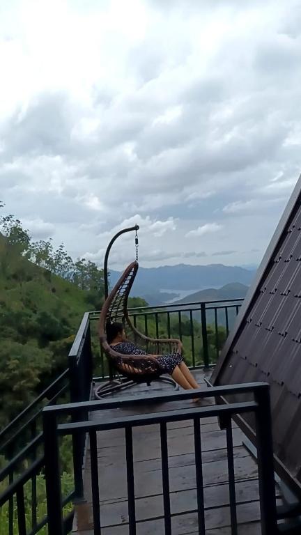 a chair sitting on top of a table on a balcony at Hilltop Heaven Cabanas 