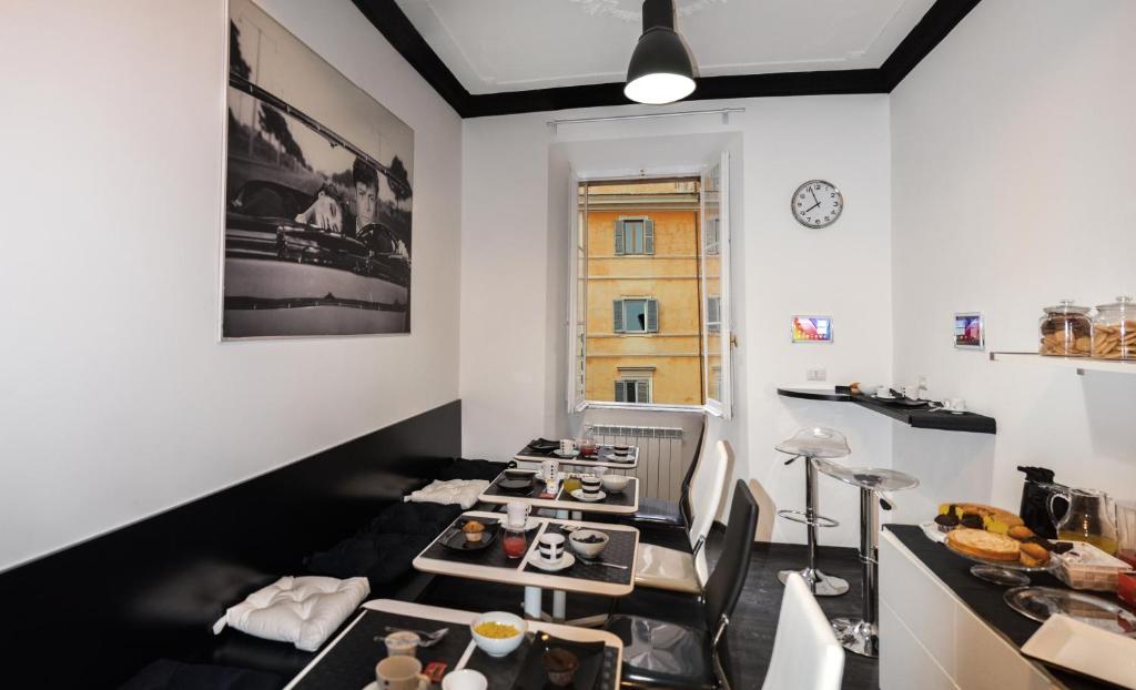 ein Esszimmer mit Tischen, Stühlen und einer Uhr in der Unterkunft Good Life Via Veneto in Rom
