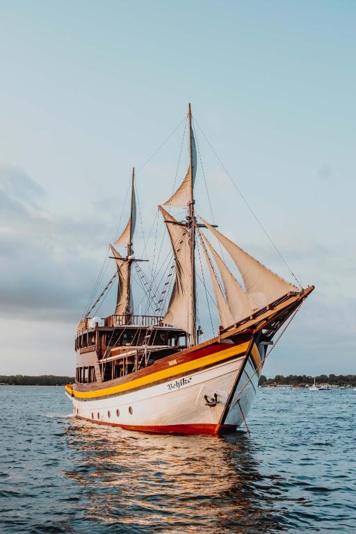 a boat is sitting in the water at Behike Luxury Phinisi in Labuan Bajo