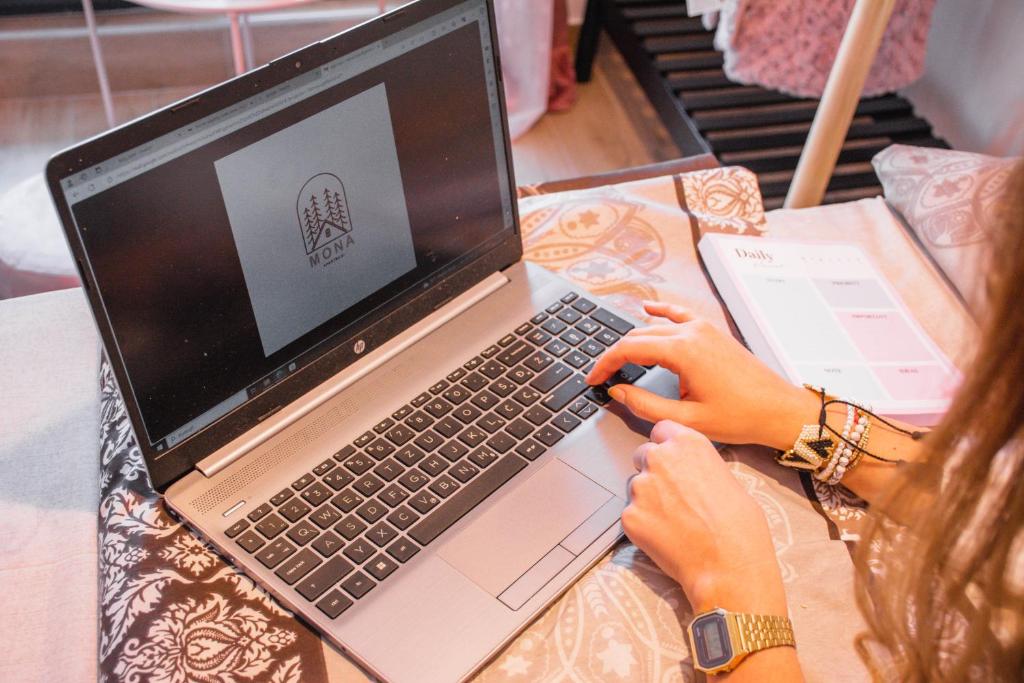 Una donna sta scrivendo su un computer portatile di MONA Apartman Divčibare a Divčibare