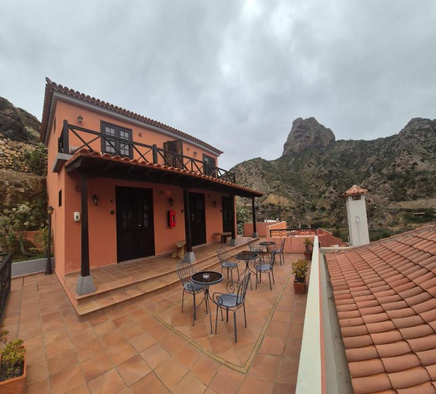 a patio with chairs and tables in front of a house at Tamahuche Hotel Rural in Vallehermoso