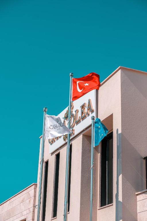 a building with two flags in front of it at Casa Olea Apart Hotel in Çeşme