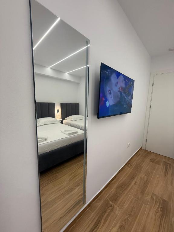 a mirror in a bedroom with a bed at Hotel Barjami in Sarandë
