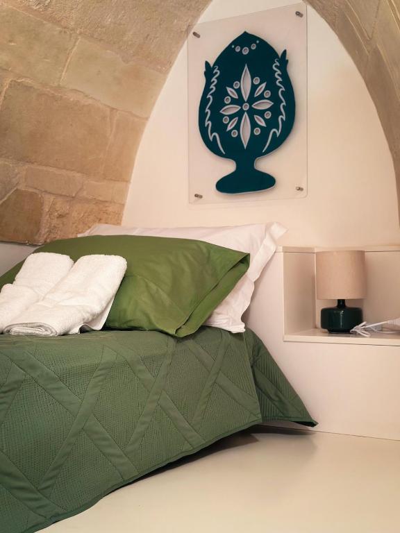 a bedroom with a green bed with a wall at Casa Tia in Lecce