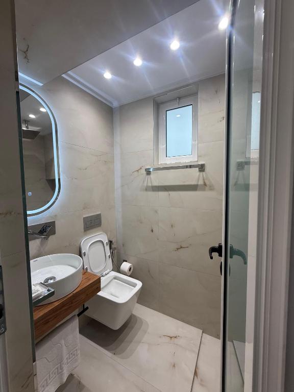 a bathroom with a toilet and a sink and a shower at Hotel Barjami in Sarandë