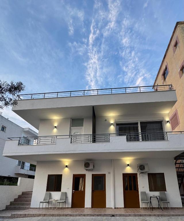 a white house with a balcony and stairs at Hotel Barjami in Sarandë
