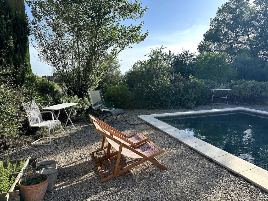 - une piscine avec 2 chaises, une table et un banc dans l'établissement Terrasse du Midi, à Aigremont
