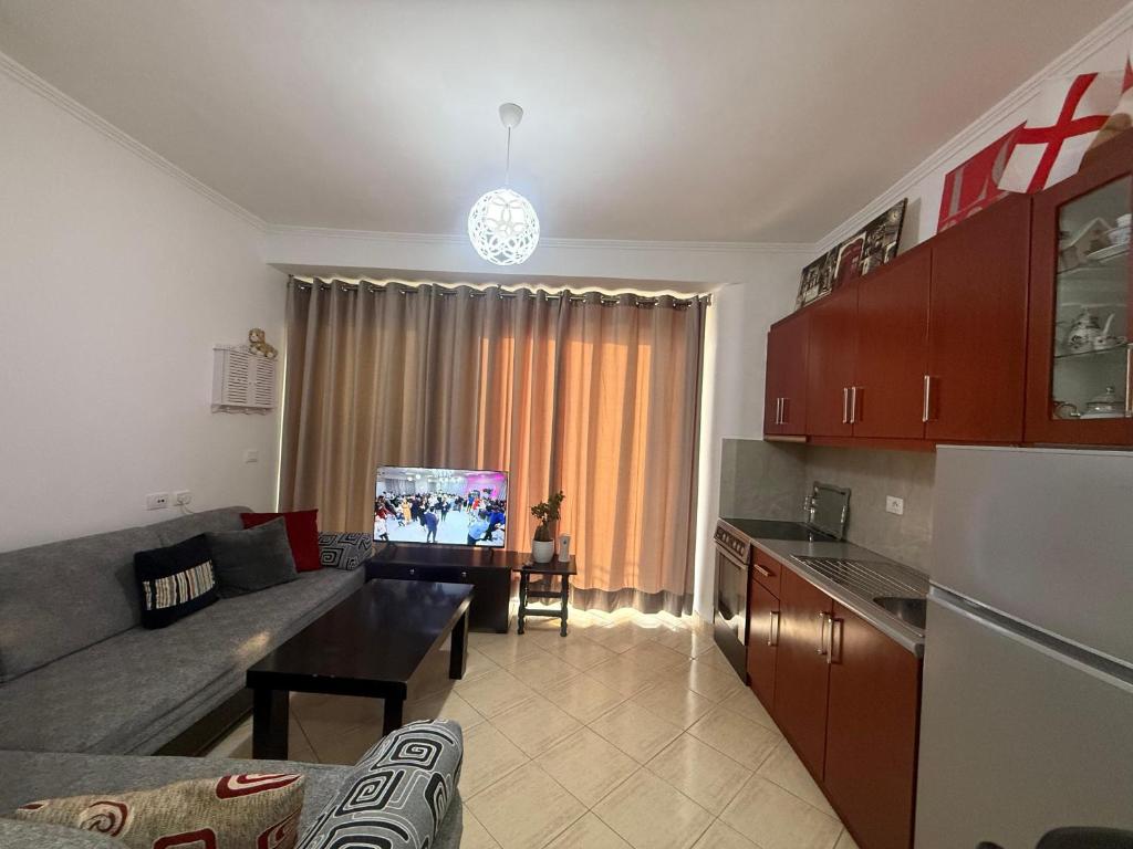 a living room with a couch and a table and a kitchen at Hotel Barjami in Sarandë