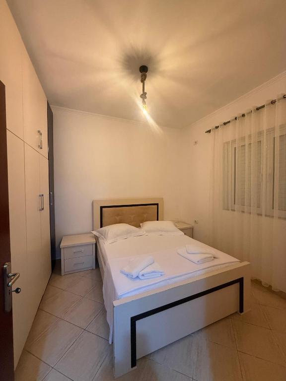 a white bed in a room with a ceiling at Hotel Barjami in Sarandë