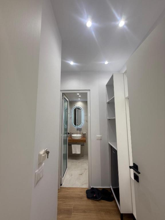 a hallway with a bathroom with a sink and a mirror at Hotel Barjami in Sarandë