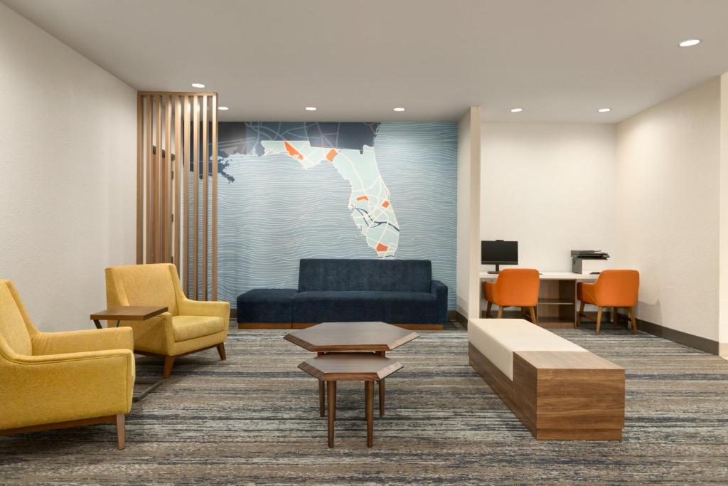 a waiting room with a blue couch and chairs at Holiday Inn Express Fort Lauderdale Airport South by IHG in Dania Beach