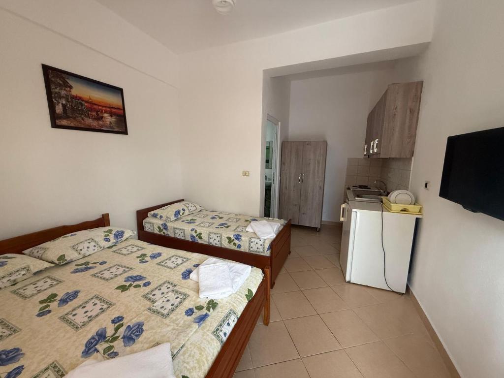 a small room with two beds and a kitchen at Hotel Barjami in Sarandë