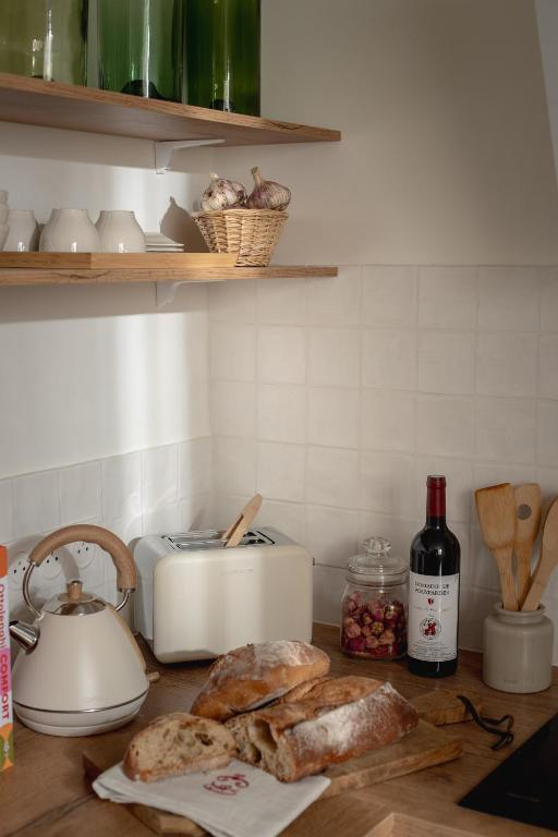 un comptoir avec du pain et un grille-pain et un grille-pain dans l'établissement Maison Valentine, à Castelnau-sur-lʼAuvignon