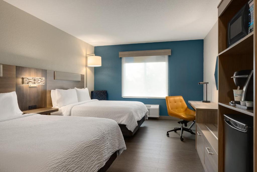 a hotel room with two beds and a window at Holiday Inn Express Fort Lauderdale Airport South by IHG in Dania Beach