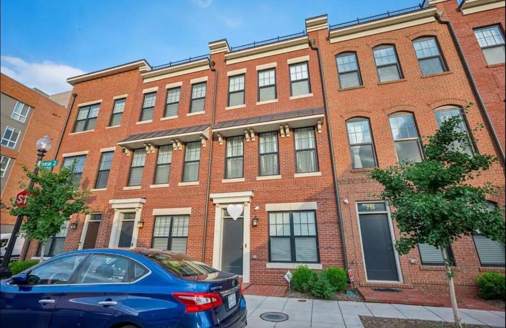 a blue car parked in front of a brick building at Luxurious 4BR home with patio and parking x Fits 8 to 10 in Washington