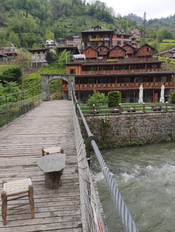 贾马里海姆森Nani Boutique Hotel & Bungalow的一座木桥,在河上,建有一座建筑