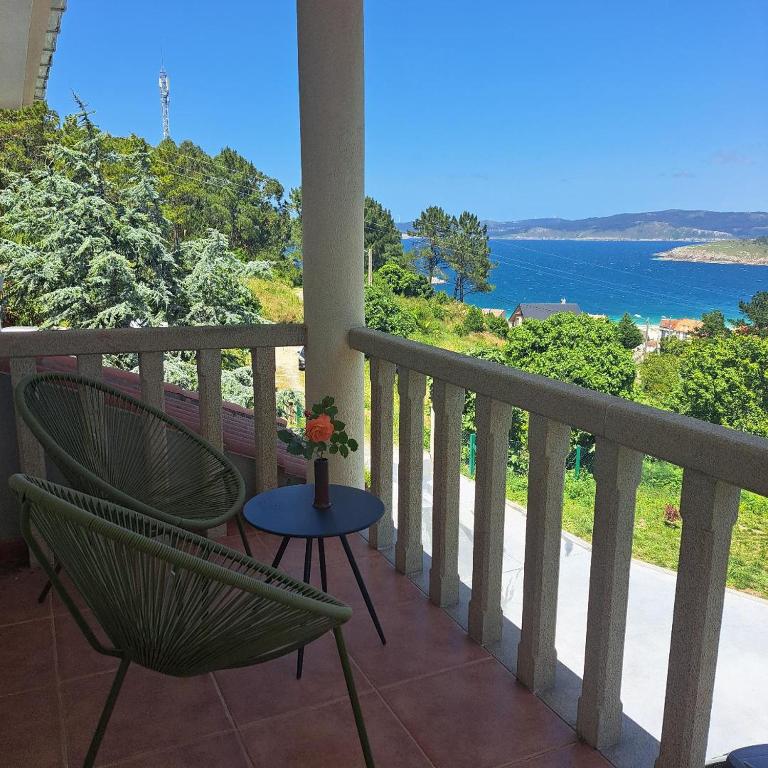 a balcony with a table and chairs and the ocean at Casa Teresa in Laxe