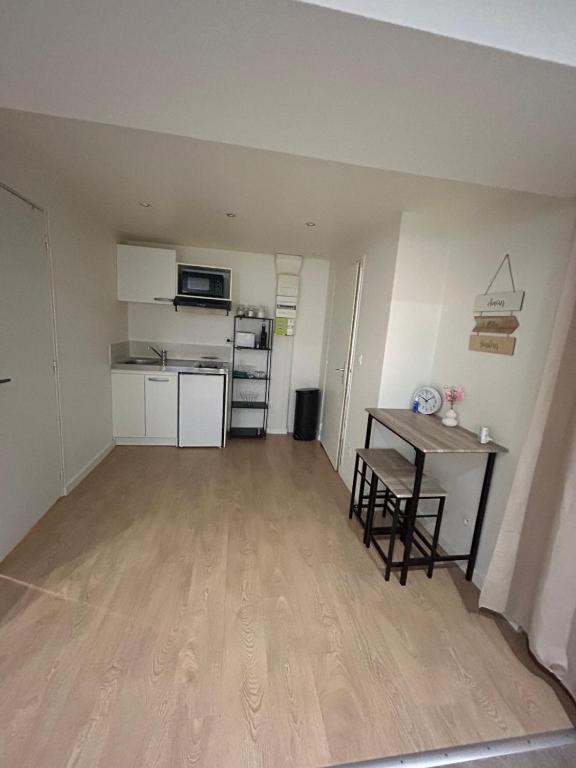 un salon vide avec une table et une cuisine dans l'établissement AS app, à Reims