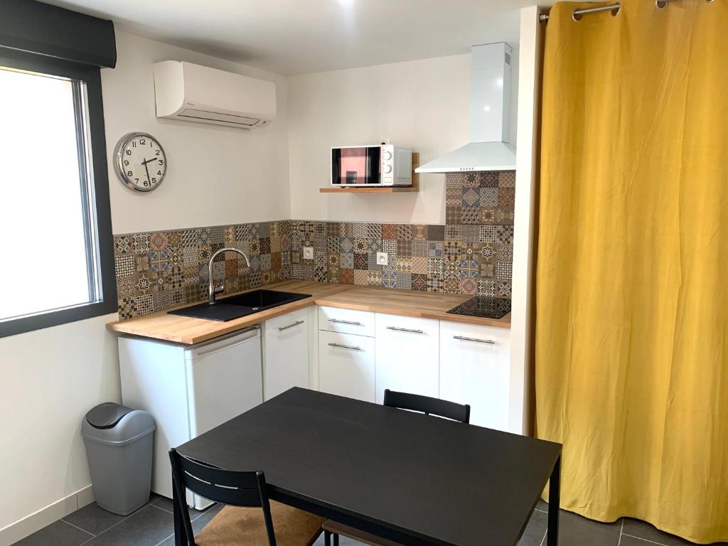 une petite cuisine avec une table et un évier dans l'établissement Studio République #2, à Perpignan