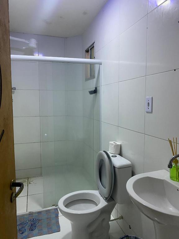 a white bathroom with a toilet and a sink at Caruaru apartamento in Caruaru