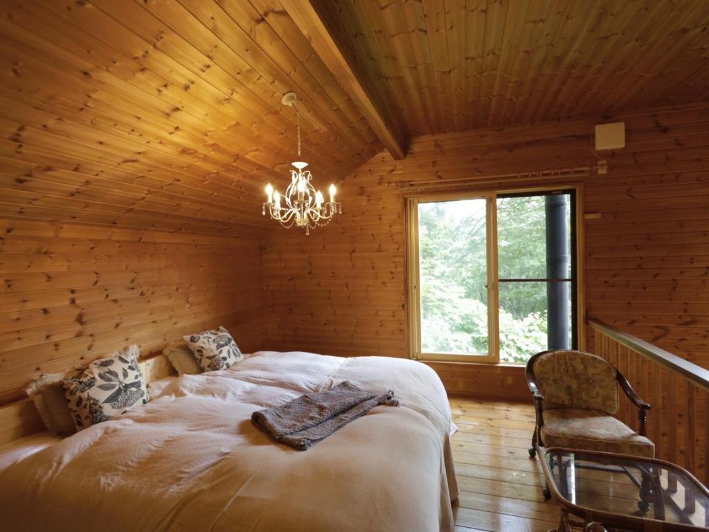 a bedroom with a large bed in a log cabin at Forest Waltz - Vacation STAY 26221v in Komoro