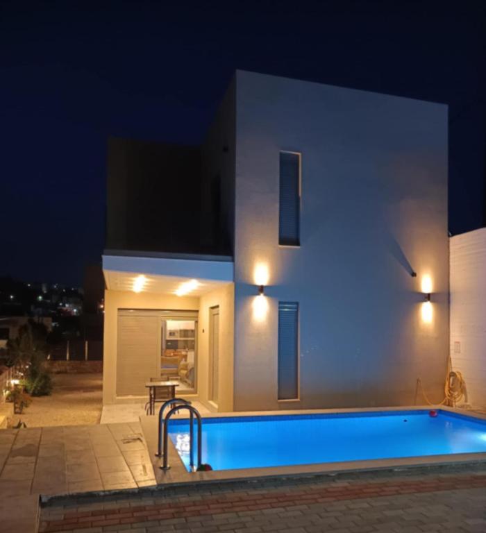 a villa with a swimming pool at night at Villa Miron in Kamilari